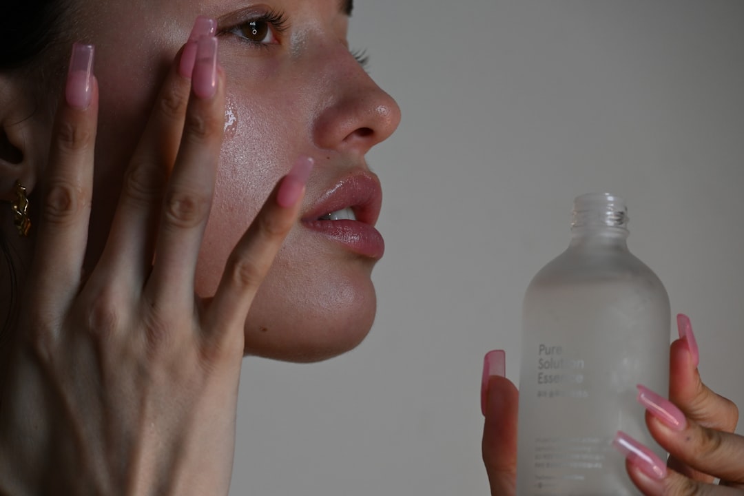 Woman applying facial serum to her cheek for a skincare routine