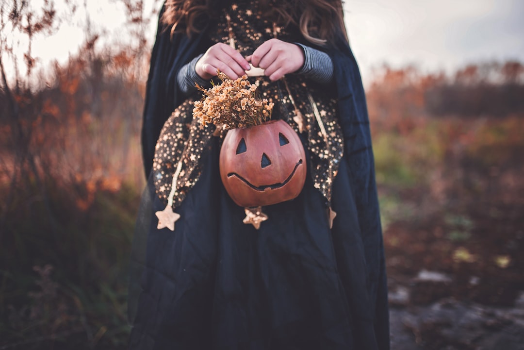 Woman in a Halloween-inspired outfit holding a pumpkin for pregnancy costume inspiration